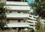 white concrete building near green trees during daytime