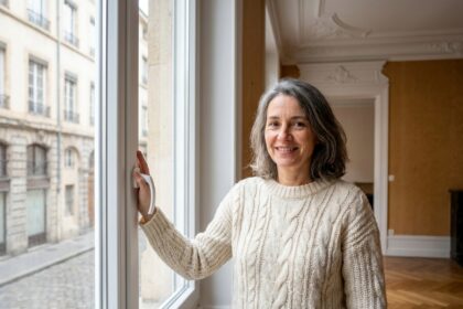 Femme devant une fenêtre double vitrage dans un appartement Haussmannien de Lyon