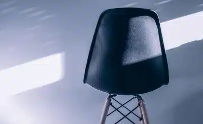 a black chair sitting on top of a wooden stand