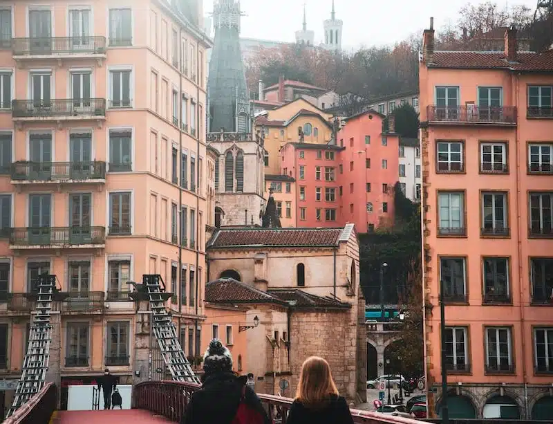 people walking on bridge near buildings during daytime